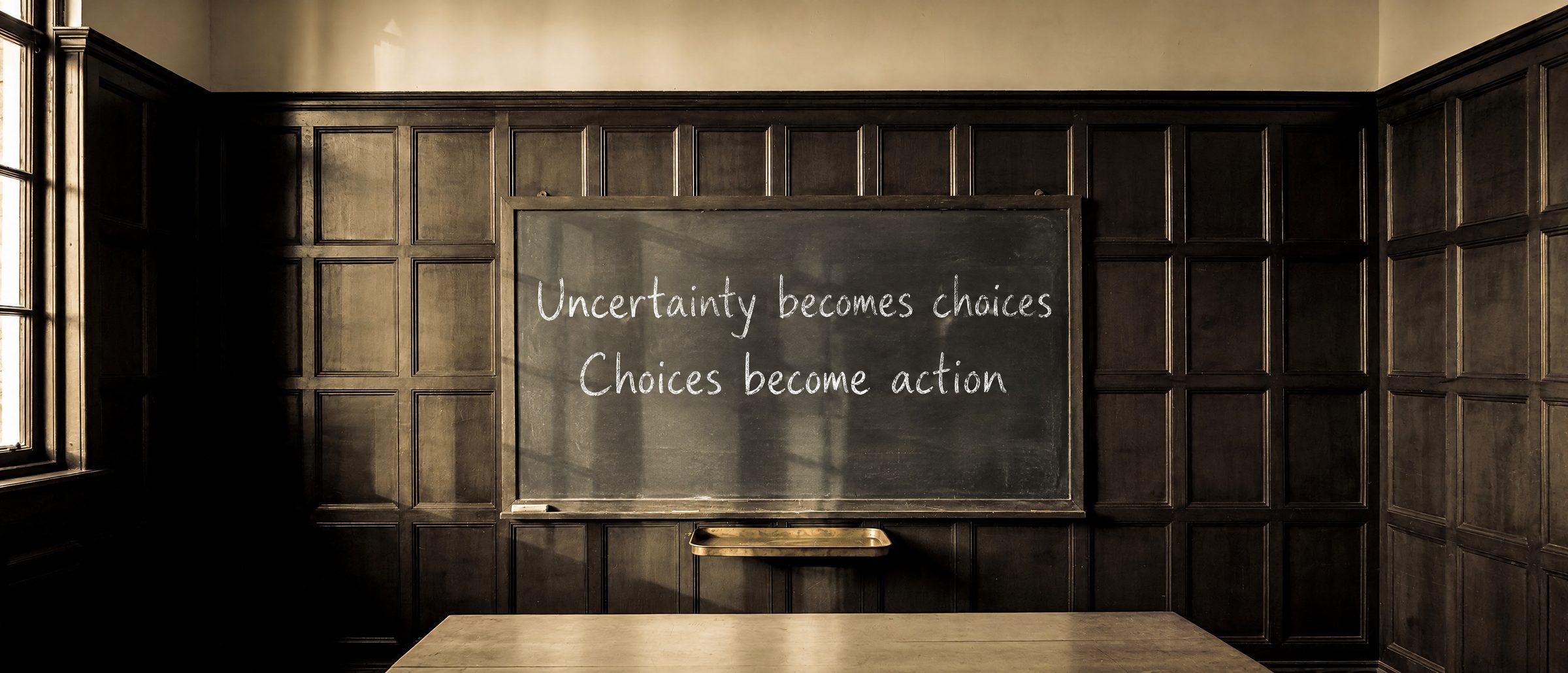 Chalkboard in a dark wood-panelled meeting room. In chalk it reads: Uncertainty becomes choices. Choices become action.